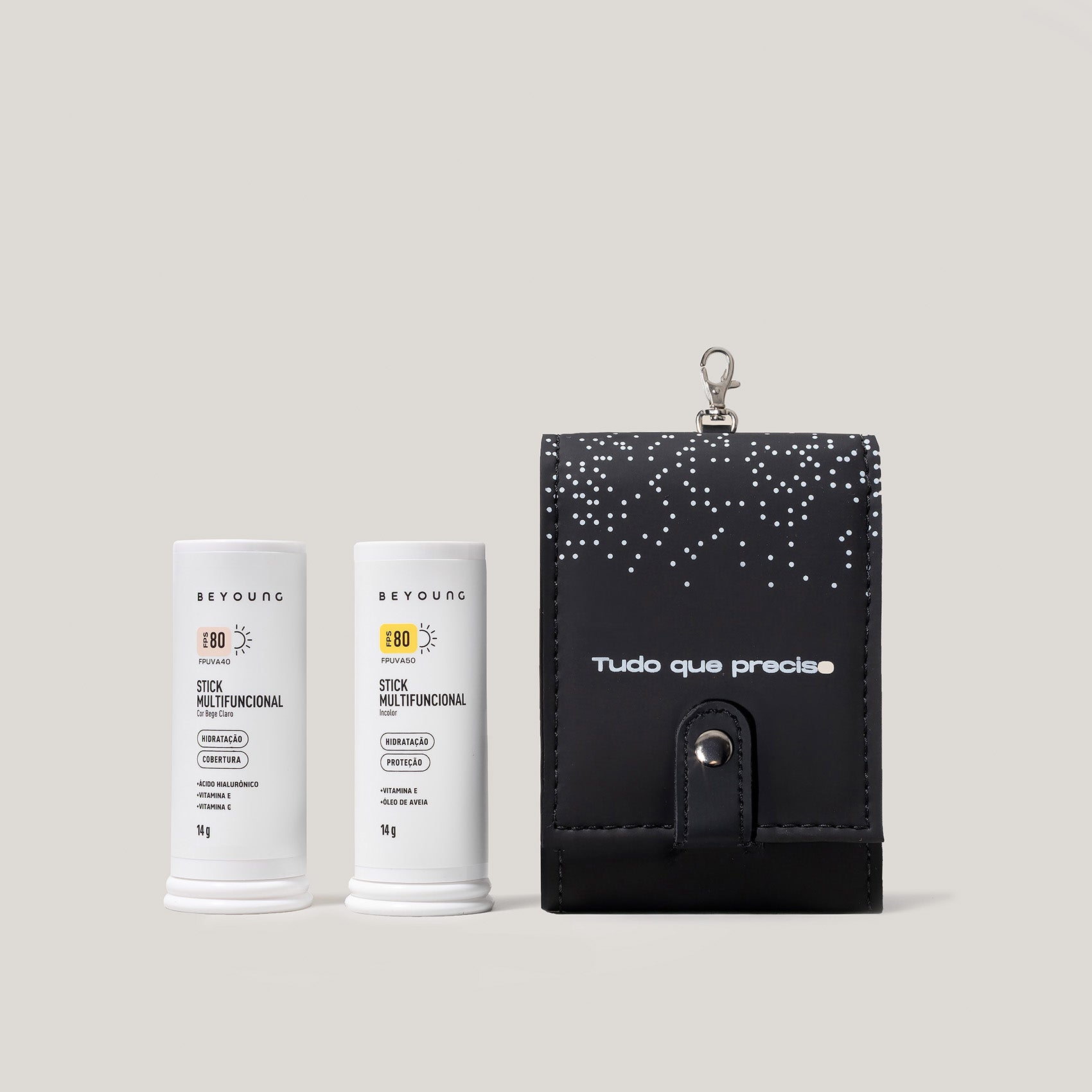 Kit Beyoung com dois Stick Multifuncional FPS 80 em embalagens brancas de 14 g e um porta-stick preto personalizado com a frase 'Tudo que preciso'.