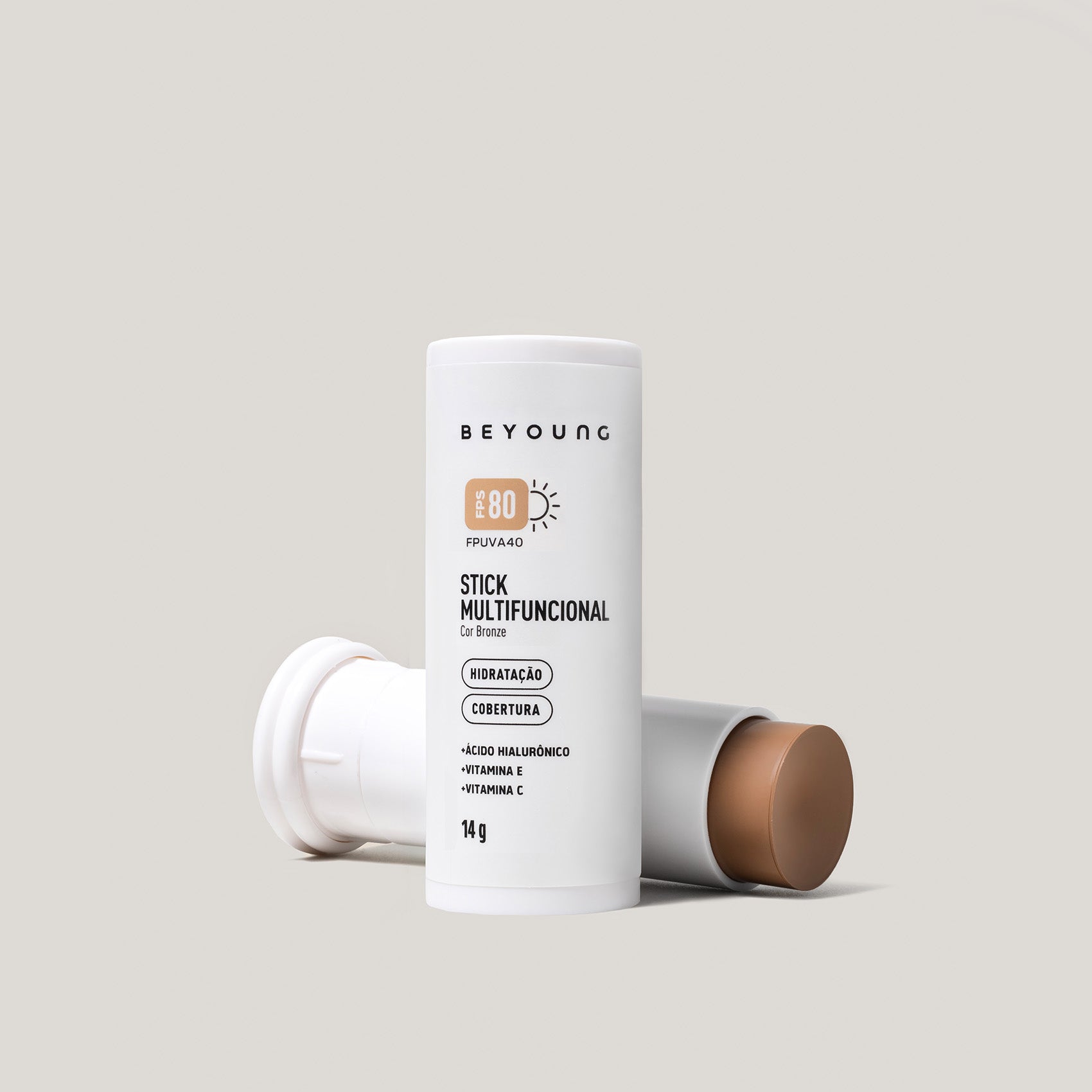 Stick Multifuncional Beyoung FPS 80 cor bronze em embalagem branca, com ácido hialurônico, vitamina E e vitamina C.